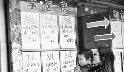 图为上海一位家长带着孩子在中介门口看“学区房”房源。