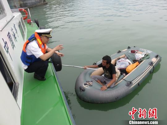 海事人员将唐某拉上海巡艇。邱翀摄