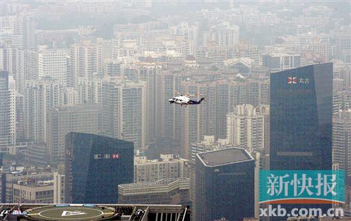 直升机飞过珠江新城CBD,即将降落在越秀金融大厦停机坪。