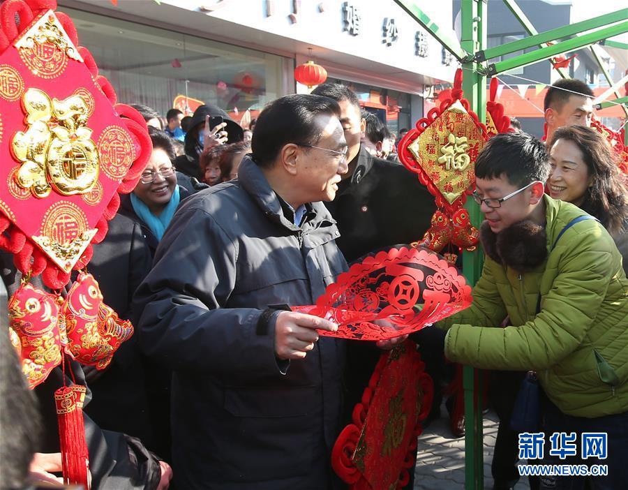 这是2月2日，李克强在银川永宁县南桥市场摊位了解节日市场行情等情况，祝商户们生意更加红火。 新华社记者 庞兴雷 摄 