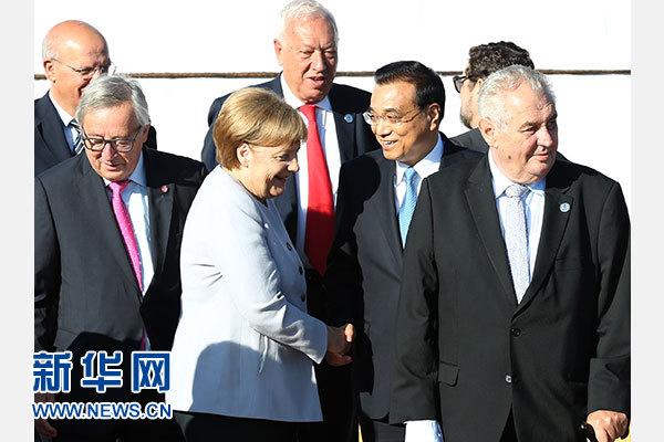 7月16日，国务院总理李克强在乌兰巴托出席第十一届亚欧首脑会议非正式会议，就国际和地区问题同与会领导人交换意见。这是会议开始前，与会领导人合影时，李克强与德国总理默克尔交谈。新华社记者马占成摄