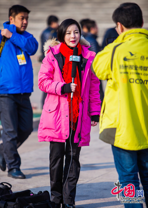 2015年3月5日，第十二届全国人大第三次会议开幕会，一位身穿玫红上衣的女记者在全国“两会”报道中展现风采。中国网 郑亮 摄