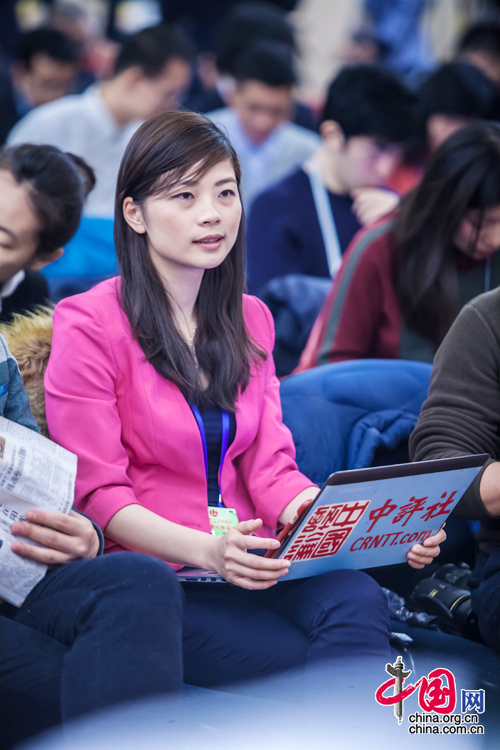 2015年3月8日，外长记者见面会，一名身穿玫红小西装的女记者认真听取外长的会议发言。中国网 郑亮 摄