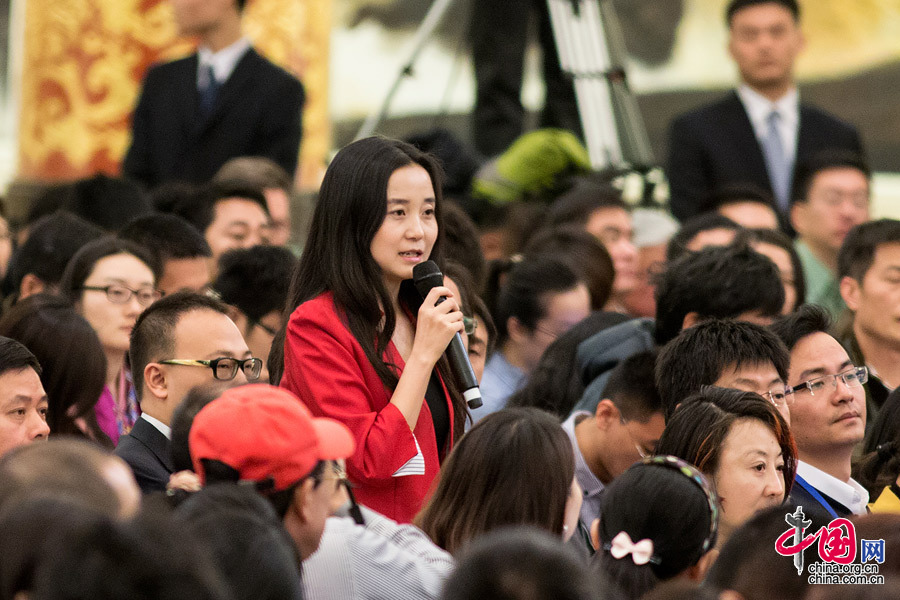 2015年两会，身穿正红小西装的第一财经美女记者在会议上提问。中国网 杨佳 摄