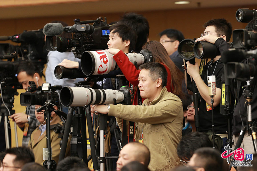  2016年3月8日，外长记者见面会，一位没露脸的红衣女记者也是“蛮拼的”，在一群长枪短炮、汉子林立的人群中显得与众不同。中国网 杨佳 摄
