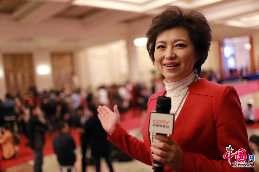  2015年3月5号，第十二届全国人民代表大会第四次会议在人民大会堂开幕，身穿红色正装的成都电视台女记者正在现场直播。中国网 杨佳 摄