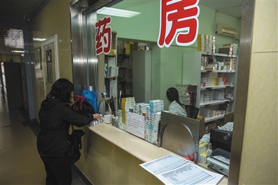 4月8日，方庄卫生服务中心，一位患者正在药房取药，台面上摆着药品新旧价格对比表。 新京报记者 彭子洋 摄