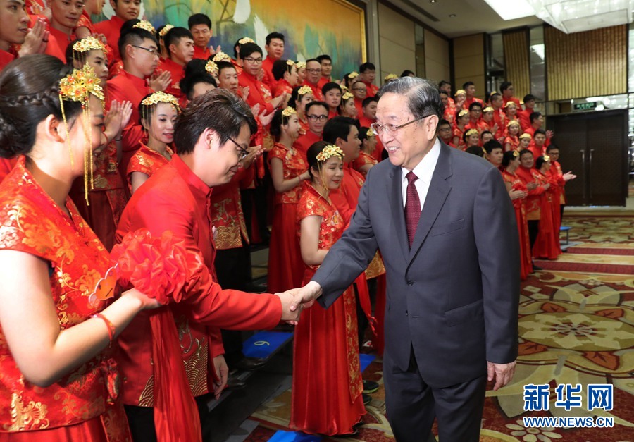 6月17日，中共中央政治局常委、全国政协主席俞正声在厦门出席“两岸美丽新人集体婚礼”活动。这是俞正声与新人握手祝贺。 新华社记者马占成 摄