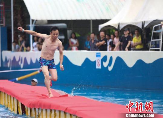 图为一男士穿着高跟鞋在水上赛道上跑。　杨孝勇　摄
