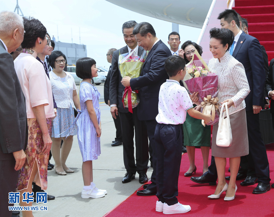 这是习近平和夫人彭丽媛在舷梯旁接受两名香港少年敬献鲜花。新华社记者 兰红光 摄