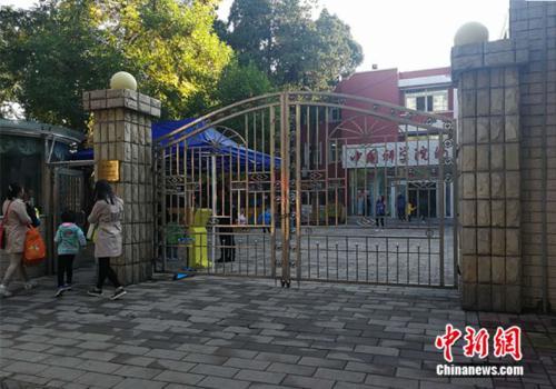 资料图：北京市某幼儿园外家长送孩子入园 中新网记者 张尼 摄