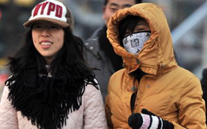 北京遭遇罕见严冬 街头行人“比拼”保暖装备
