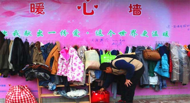 广西现“暖心墙” 市民街边挂衣物供需要者取用