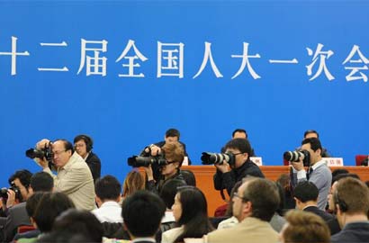 几名记者在拍摄提问的记者