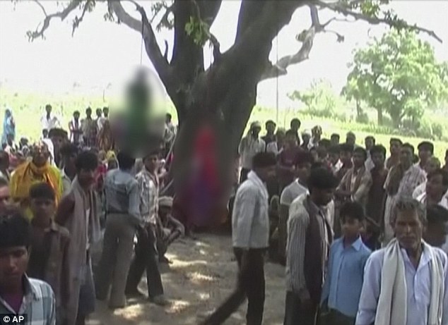 当地村民聚集在挂有尸体的树周围，据悉，实施轮奸者中还包括一名警察