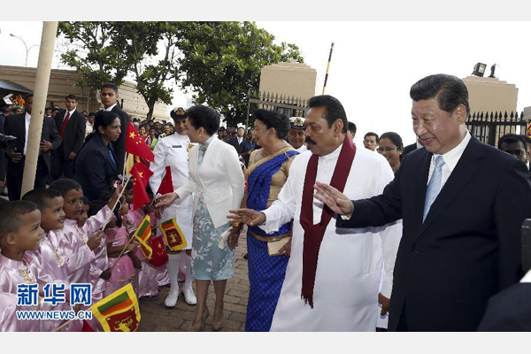 9月16日，斯里兰卡总统拉贾帕克萨在科伦坡为国家主席习近平举行盛大欢迎仪式。斯里兰卡儿童身着节日服装，站在红地毯两侧，挥舞中斯两国国旗。习近平和夫人彭丽媛走到孩子们面前向他们问好。新华社记者鞠鹏摄