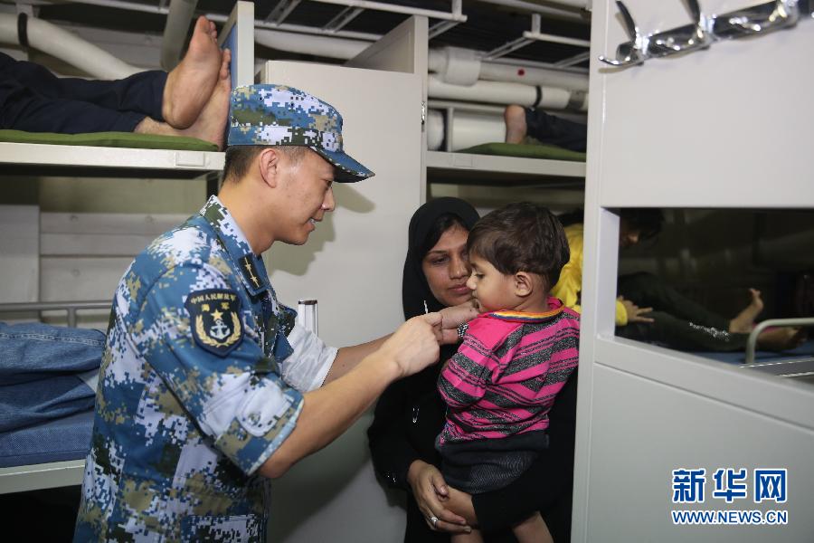 4月2日，在临沂舰上，随舰医疗队员准备为一名外籍幼童量体温。