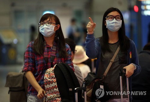 资料图片：1日上午，通过仁川国际机场入境韩国的外国游客大都戴着口罩。（韩联社）