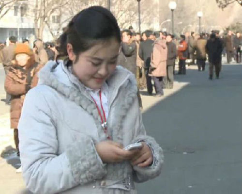 一位平壤姑娘在玩手机（朝鲜科技网站）