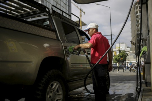 委内瑞拉首都加拉加斯的工作人员给车加油。（图片来源：路透社）