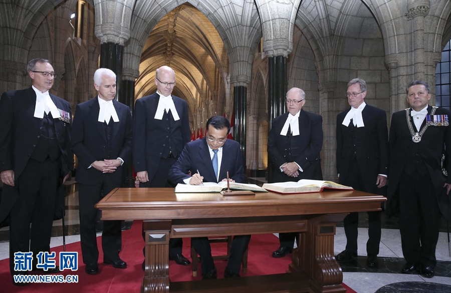 9月22日，国务院总理李克强在渥太华议会大厦会见加拿大参议长富里和众议长里甘。这是李克强在参众两院贵宾簿上签名。 新华社记者 庞兴雷摄 