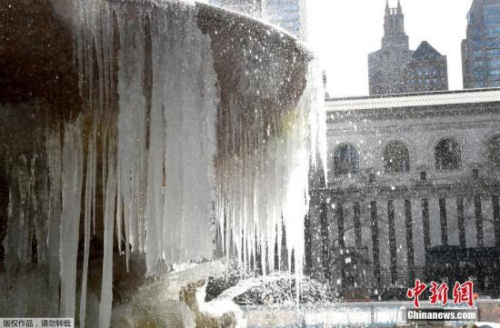 图为当地时间3月13日，美国纽约布莱恩公园内的喷泉被冰覆盖。