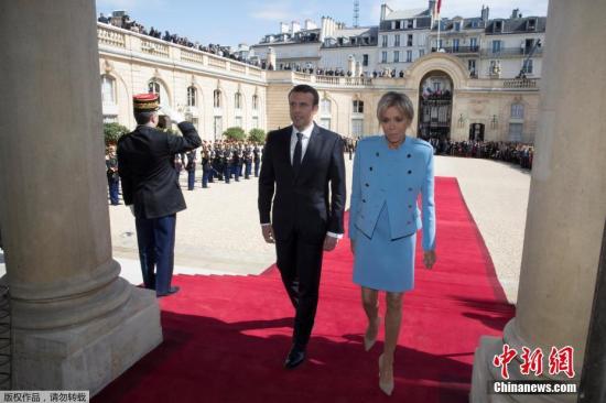 资料图：法国总统马克龙与夫人布丽吉特・特罗尼厄步入爱丽舍宫。