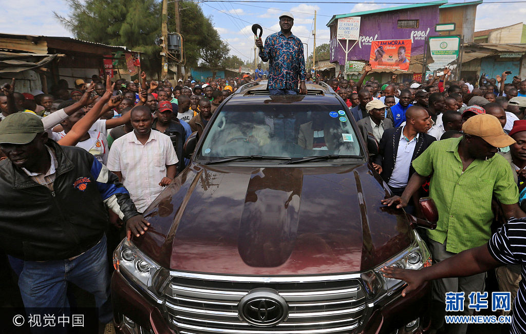 当地时间2017年8月13日，肯尼亚内罗毕，肯尼亚反对党支持者举行游行，抗议总统选举结果，反对党候选人奥廷加现身游行现场。***_***Opposition leader Raila Odinga greets supporters as he arrives to address a rally in Kibera slum, Nairobi, Kenya, August 13, 2017. Thomas Mukoya