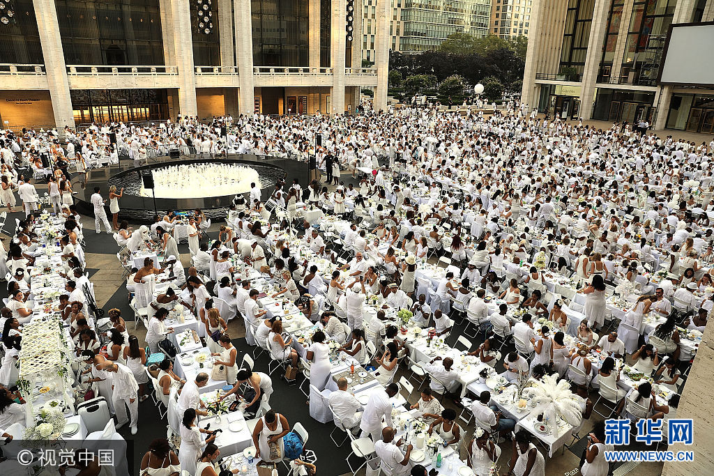 当地时间2017年8月22日，美国纽约，在纽约的林肯艺术中心，数千人参加了一年一度的白色长街宴。***_***NEW YORK, NY - AUGUST 22:  Thousands of diners participate in the annual 'Diner en Blanc' (Dinner in White) at Lincoln Center on August 22, 2017 in New York City. Diner en Blanc began in France nearly 30 years ago. Attendees all must wear white clothing and bring their own picnic food and white tables clothes. It's the second time the event, which is held in cities around the world, has been held at Lincoln Center.  (Photo by Spencer Platt/Getty Images)