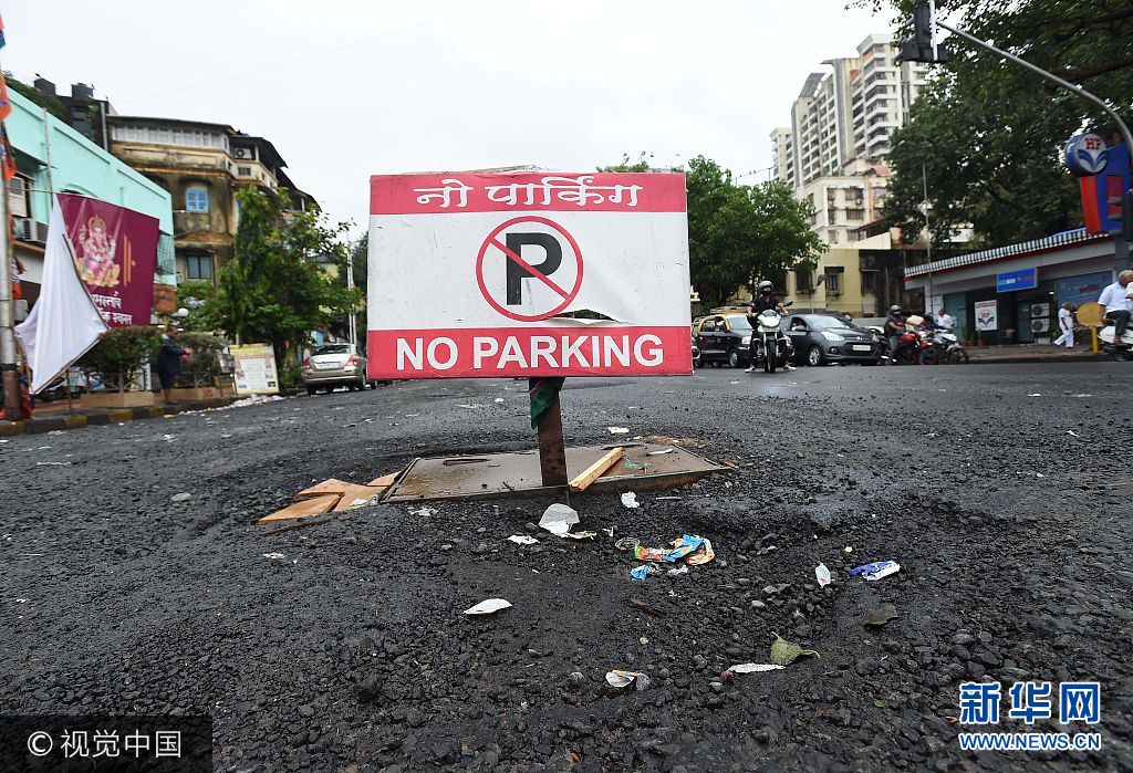 当地时间2017年8月30日，印度孟买，由于多日的连续强降雨导致当地大量道路被淹没，民众出行受阻，另造成多班次列车停运，大量旅客滞留车站。***_***MUMBAI, INDIA - AUGUST 30: To Prevent Pothole No Parking Sign board as been put at Matunga S.V Road near Shobha Hotel on August 30, 2017 in Mumbai, India.  Heavy monsoon rains have brought Mumbai to a halt for a second day as many areas like Sion, Kings Circle, Kurla, Bandra, Mahim, Dadar, and Matunga were remain flooded.(Photo by Vijayanand Gupta/Hindustan Times)