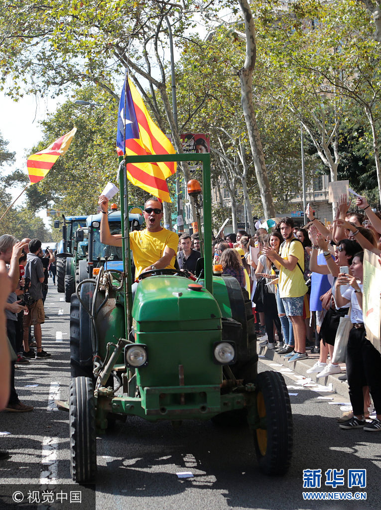 当地时间2017年9月29日，西班牙巴塞罗那，农民开拖拉机游行支持加泰罗尼亚地区独立公投。***_***Farmers are applauded as they drive their tractors through the city in a protest to show support for the banned referendum on independence from Spain in Barcelona, Spain September 29, 2017. Enrique Calvo