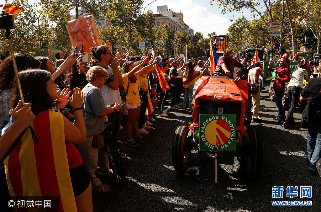 当地时间2017年9月29日，西班牙马德里，农民开拖拉机游行支持加泰罗尼亚地区独立公投。***_***Farmers are applauded as they drive their tractors past the university in a protest to show support for the banned referendum on independence from Spain in Barcelona, Spain, September 29, 2017. Juan Medina