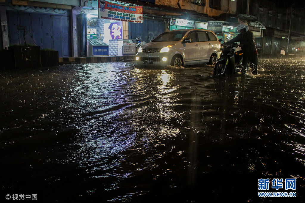 印尼突遭暴雨袭击街道被淹 民众艰难出行