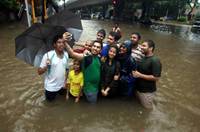 孟买暴雨引发洪灾 民众涉水出行苦中作乐