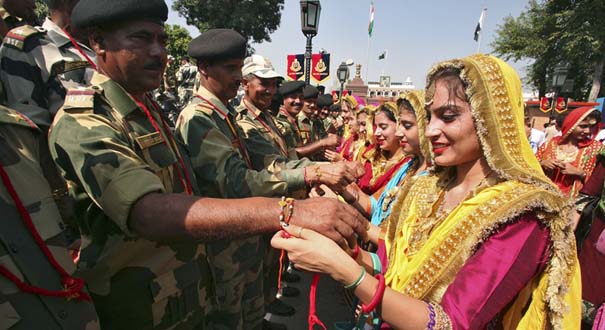 印度“保护绳节”上女子为士兵戴绸带